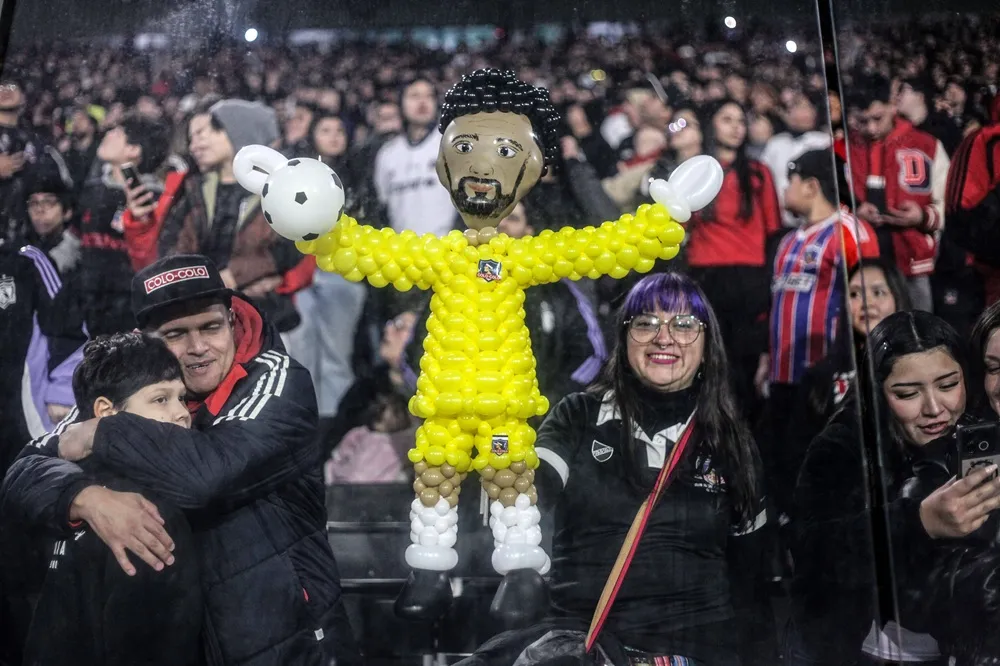 Hinchas de Colo-Colo muestran una figura de globos de Vozinha durante su presentación en el Estadio Monumental.